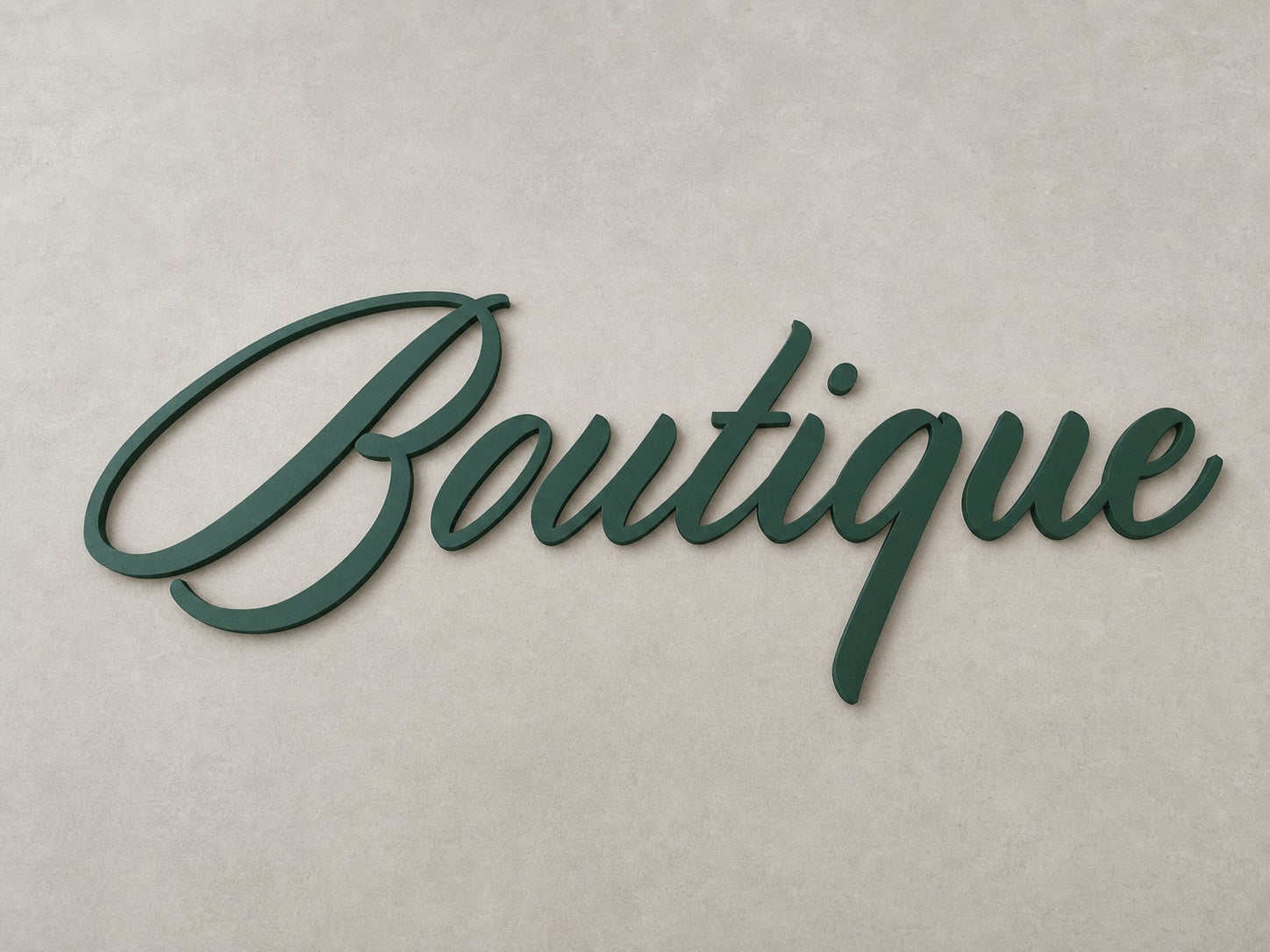 Dark green painted metal script letters on a clean production surface